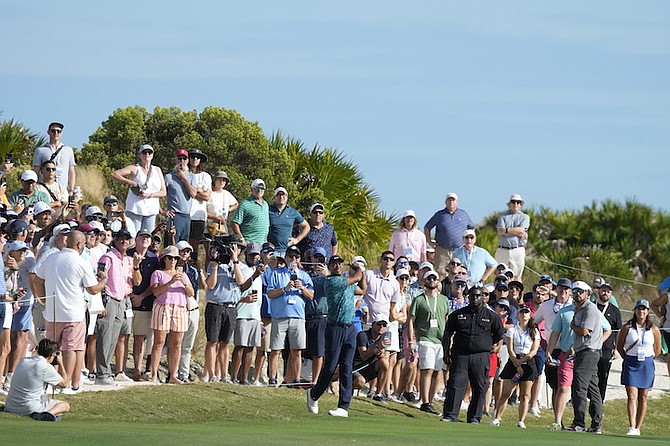Tiger Woods, centre, watches his shot from the 18th fairway during the second round of the Hero World Challenge PGA Tour at the Albany Golf Club, in New Providence, Bahamas, Friday, Dec. 1, 2023. (AP Photo/Fernando Llano)