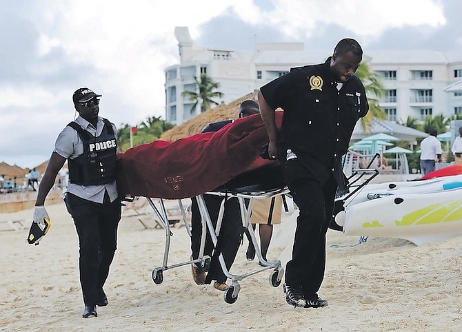 MORTUARY services personnel transport the body of US woman Lauren Erickson Van Wart, 44, after she was killed in a shark attack in waters off Sandals Beach on Monday. Photo: Dante Carrer