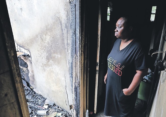 CAROLYN Lewis viewing what is left of her home on Kiskadee Dr yesterday. The structure was severely damaged by fire on Sunday.
Photos: Dante Carrer