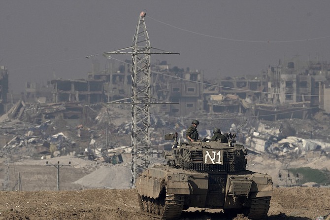 Israeli soldiers overlook the Gaza Strip from a tank, as seen from southern Israel, on Friday. Photo: Maya Alleruzzo/AP