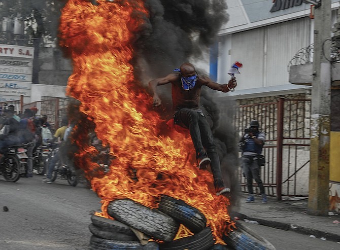 A PROTESTER jumps on burning tires during a protest against Haitian Prime Minister Ariel Henry in Port-au-Prince, Haiti, on Monday, February 5. Photo: Odelyn Joseph/AP