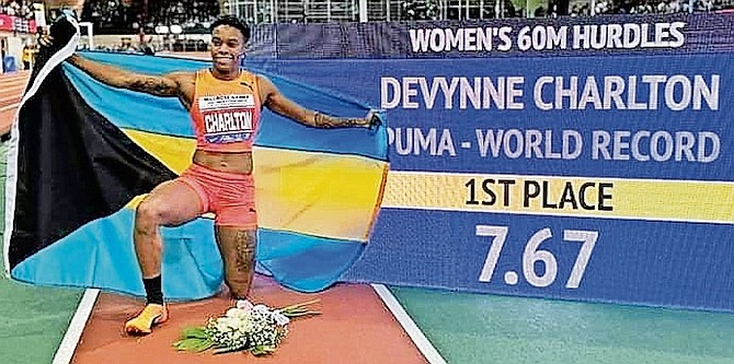 ON TOP OF THE WORLD: Devynne Charlton proudly displays the Bahamian flag yesterday after setting the world indoor record in the 60 metre hurdles at the Millrose Games in New York.