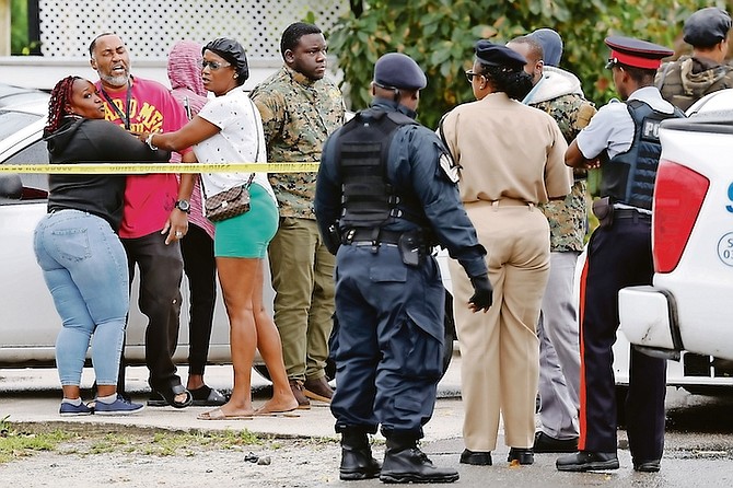 VISIBLY distraught onlookers at the scene where 15-year-old Chester Forbes Jr was killed in a drive-
by shooting on Monday.
Photo: Dante Carrer