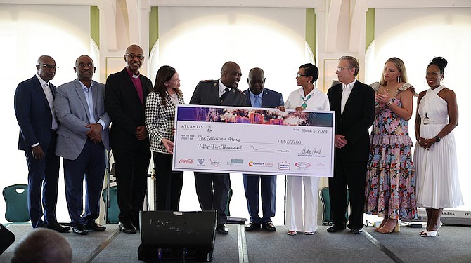 MAJOR Roodolph Meo (left of Prime Minister Davis) accepts a donation on behalf of The Salvation Army during a charity event at Atlantis in celebration of The Royal’s 25th anniversary held at Cafe Martinique yesterday. Photos: Dante Carrer