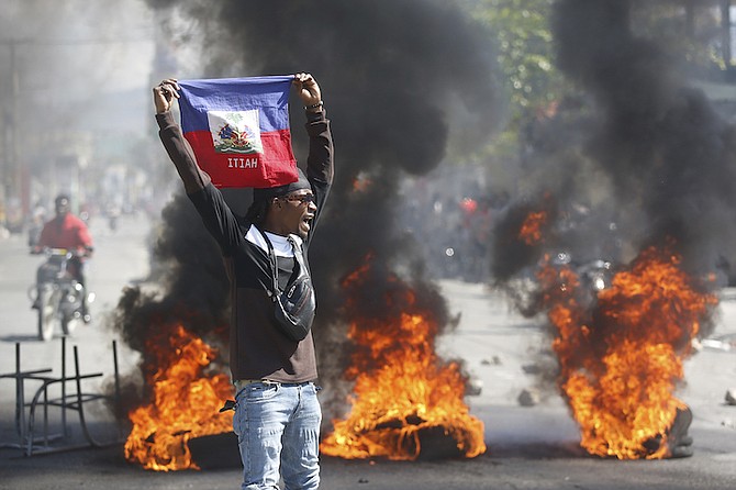 A demonstrator holds up an Haitian flag during protests demanding the resignation of Prime Minister Ariel Henry in Port-au-Prince, Haiti, Friday.
Photo: odelyn Joseph/AP