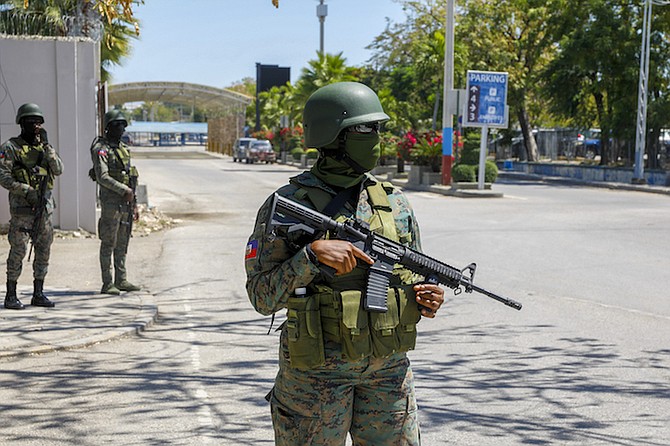 SOLDIERS guard the entrance of the international airport in Port-au-Prince, Haiti, yesterday. Authorities ordered a 72-hour state of emergency starting Sunday night following violence in which armed gang members overran the two biggest prisons and freed thousands of inmates over the weekend.
Photos: Odelyn Joseph/AP