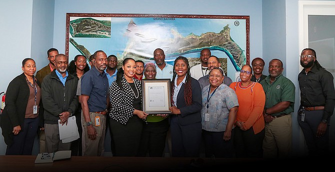 Staff at the Building and Development Services at the Grand Bahama Port Authority show off the ISO certification.