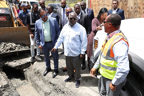 From left are Minister of Works and Family Island Affairs Clay Sweeting, Prime Minister Philip "Brave" Davis and Ministry of Works Senior Drainage Engineer Henry Moxey during a walk through Downtown Nassau on April 10, 2024. Photo: Dante Carrer