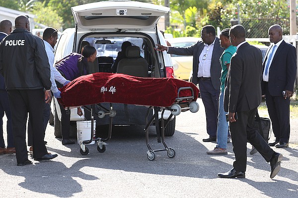 The body of DeMarcus McIntosh being taken from the scene on Nelson Street in Yellow Elder after he was shot to death by a high-powered weapon on Monday. Photo: Dante Carrer