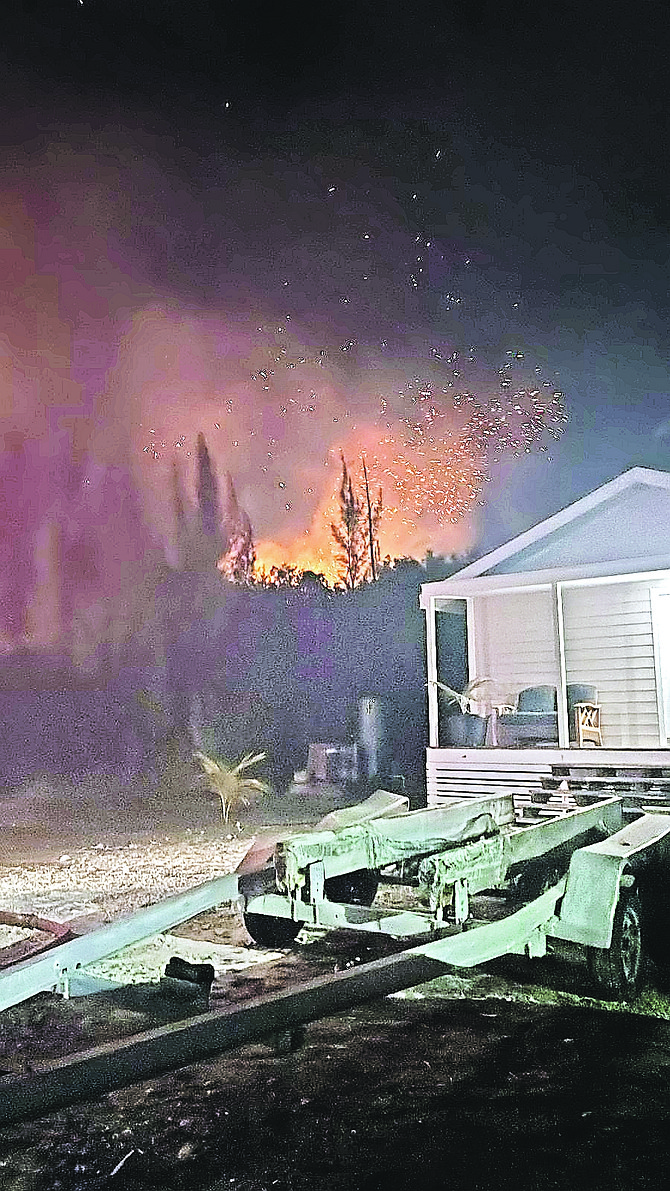 Forest fire burns near a residence in Marsh Harbour, Abaco, over the weekend. Fires continue to impact residents while police have a suspected arsonist in custody.