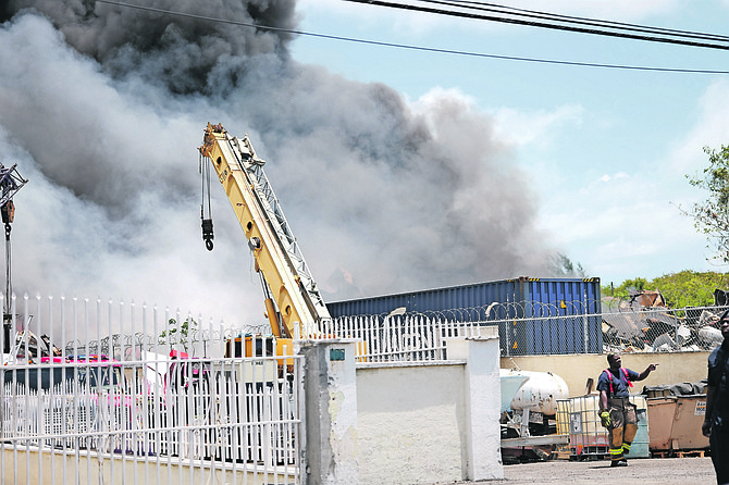 Fire personnel battle a blaze at a scrap metal yard on Joe Farrington Road yesterday. Photos: Chappell Whyms Jr