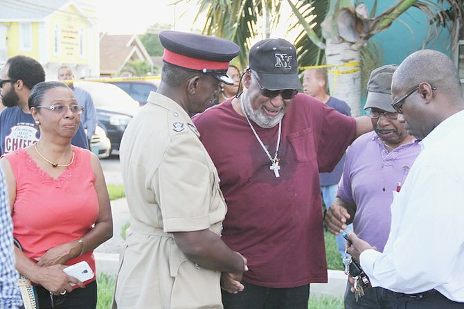 Superintendent Stephen Dean comforts Charles and George McCartney, the brothers of the fire victim, along with Dr Kendal Major. Photos: Tim Clarke/Tribune Staff
