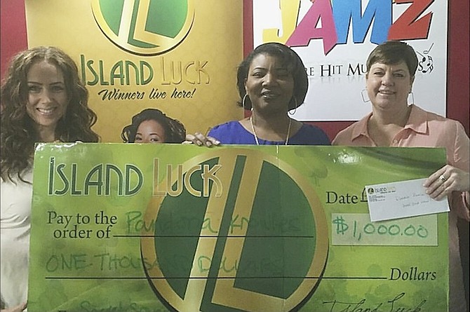 Pandora Knowles receives her prize for correctly identifying the Secret Sound from 100 Jamz on-air personality and Director of Promotions/Online Marketing at Radio House JJ McKenzie (left) and Island Luck Marketing Executive Michelle Fox (right).