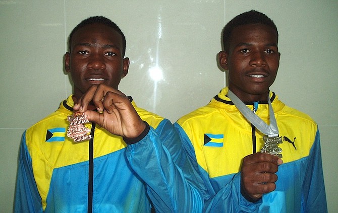 Boys under-20 pole vault bronze medalist Ramel Poitier and silver medalist Douvankiylin Rolle display their hardware.