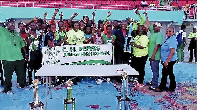 WE ARE THE CHAMPIONS: The CH Reeves Raptors celebrate yesterday after dominating the Government Secondary Schools Sports Association Junior Track and Field Championships.