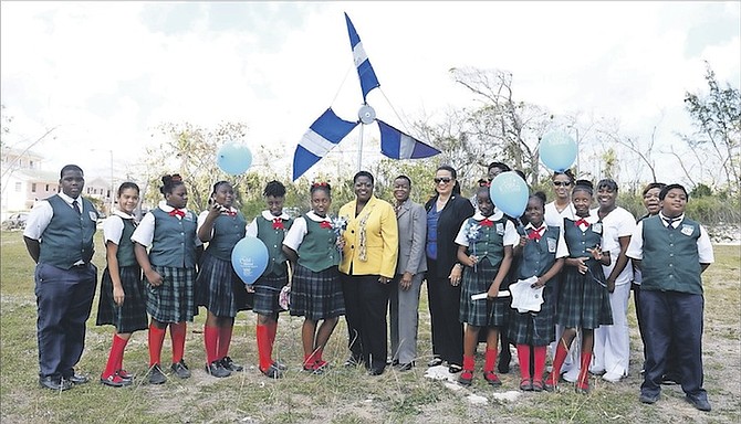 Minister of Social Services Melanie Griffin, Director of Social Services Melanie Zonicle and other members of the Ministry of Social Services and The National Child Protection Council are pictured with students of Uriah McPhee Primary School at a pinwheel that has been placed on Montagu roundabout. Photo: Shawn Hanna/Tribune Staff