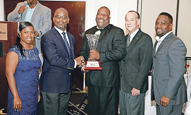 Ministry of Works ‘2017 Employee of the Year’ William Brown, centre, receives his award from Parliamentary Secretary Iram Lewis, second left. Permanent Secretary Colin Higgs is second right, with members of the committee. Photo: Derek Smith/BIS
