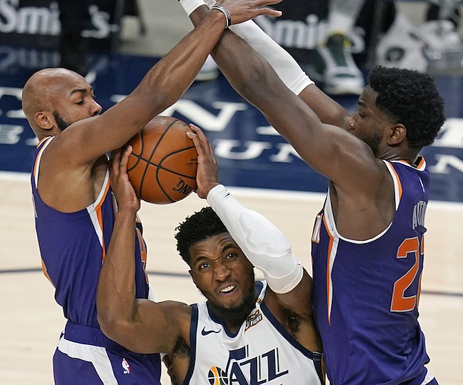 Phoenix Suns' Jevon Carter, left, and Deandre Ayton, right, defend against Utah Jazz guard Donovan Mitchell (45) during the first half of an NBA preseason basketball game Saturday, in Salt Lake City. (AP Photo/Rick Bowmer)