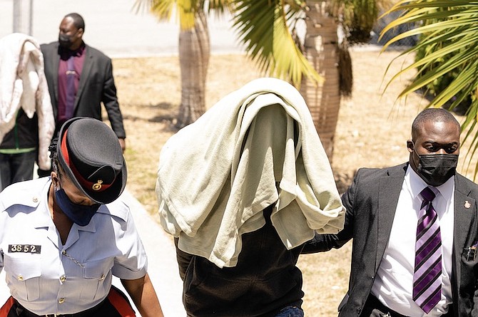 A 15-YEAR-OLD and 16-year-old outside court yesterday, where they were charged with the murder
of Government High School student Kenm Paul as well as an attempted murder of another teen. Photo: Donovan McIntosh/Tribune Staff