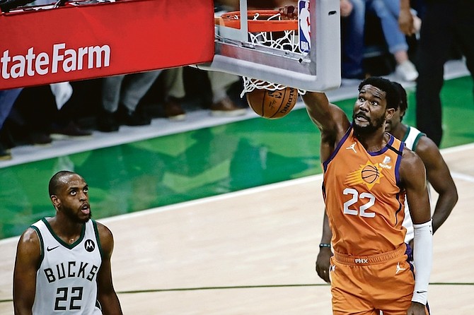 Phoenix Suns centre Deandre Ayton dunks the ball ahead of Milwaukee Bucks forward Khris Middleton, left, during the first half of Game 4 of basketball’s NBA Finals Wednesday, in Milwaukee. (AP Photo/Aaron Gash)