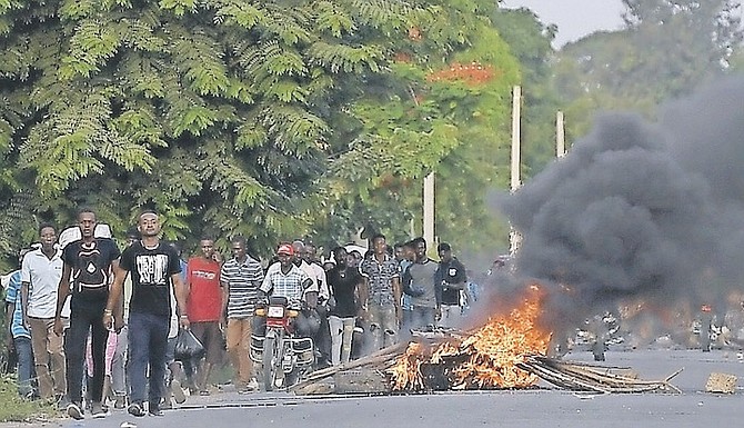 MEN walk past a flaming barricade after violence broke out and hundreds of workers fled the area when demonstration near the home town of late President Jovenel Moise grew violent, ahead of his funeral
in Quartier Morin, a districto of Cap Haitien, in northern Haiti, yesterday. Photo: Matias Delacroix/AP