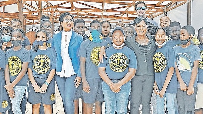 ANN MARIE DAVIS, of the Office of the Spouse, and Minister of Grand Bahama Ginger Moxey with young mangrove restoration volunteers.