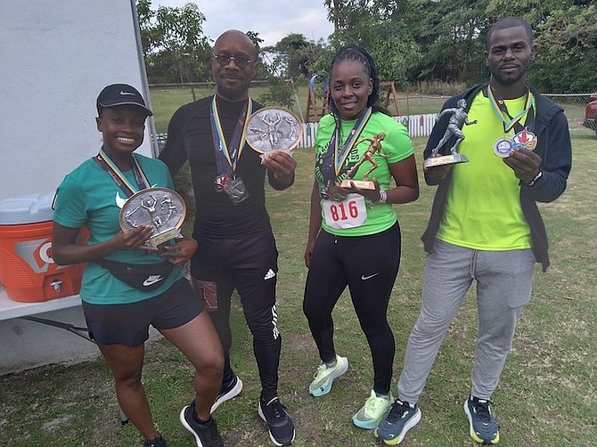 Walk winners Alicia Williams and Earl Bethel and run walkers Holly Ferguson and Anthony Saunders pose above from left to right with their awards.