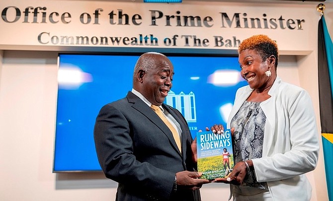 Pauline Davis presenting a copy of her biography, Running Sideways to Prime Minister Philip “Brave” Davis.