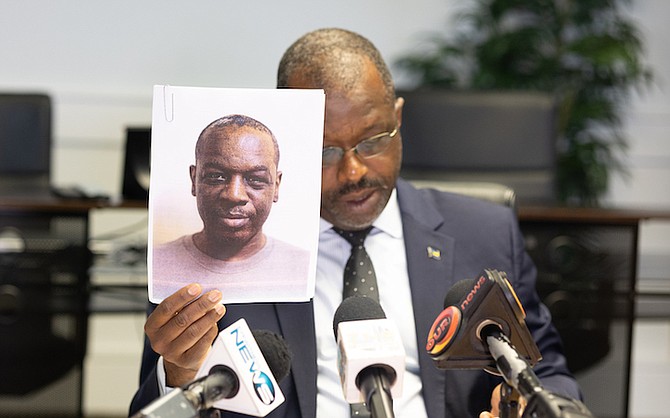 Minister of National Security Wayne Munroe shows a photo of a sex offender to be released from prison today.
Photo: Moise Amisial