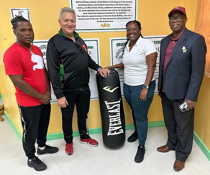 BOXING equipment for Uriah McPhee was presented to Wanda Burrows by former boxer Andrew Albury. At left is Valentino Knowles and at right is Vincent Strachan.