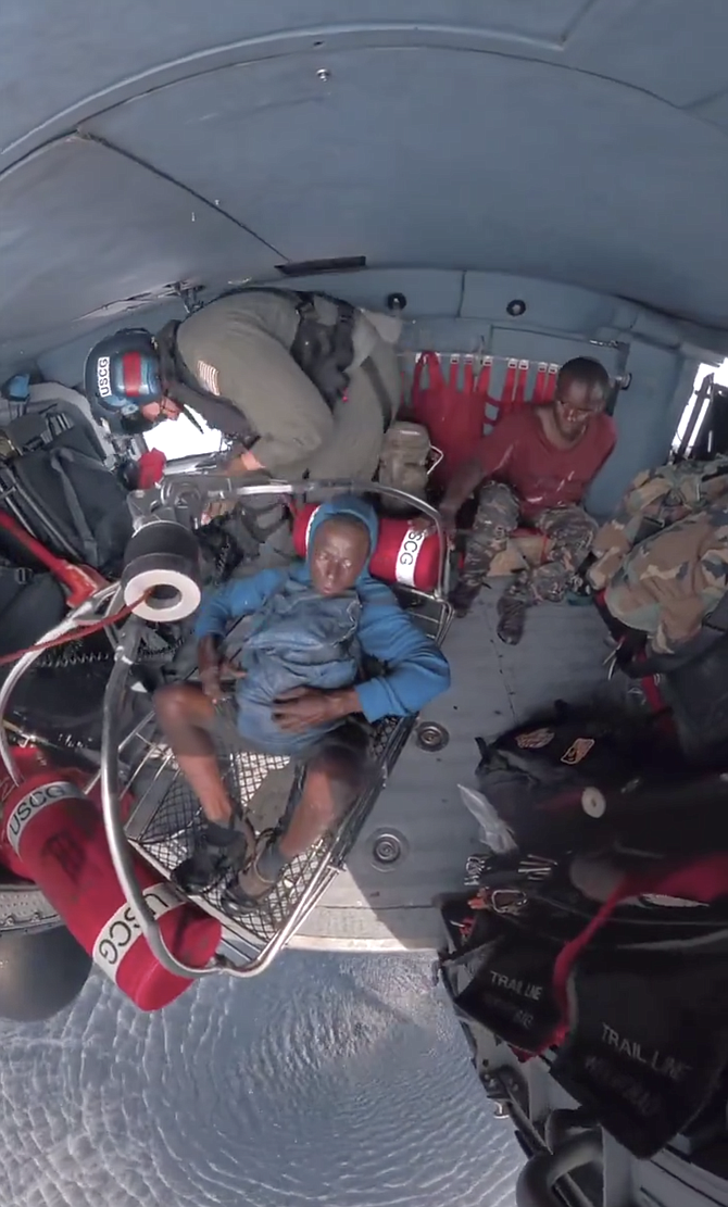 Two men aboard a helicopter after being rescued from a disabled vessel. Photo: US Coast Guard