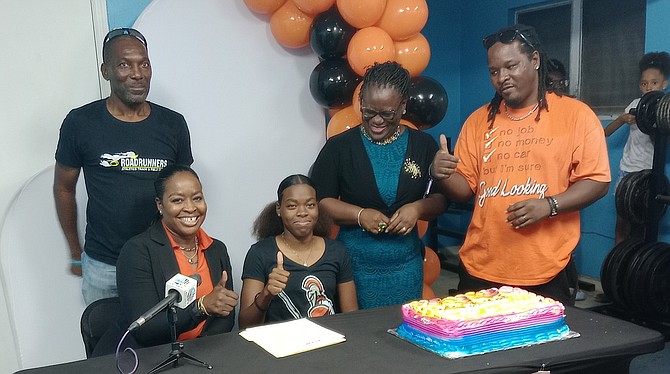 Coach Dexter Bodie, Kissie Rolle-Wilson, Ta-mia Wilson, principal Junann Lewis and Angelo Wilson give thumbs up after the college signing.