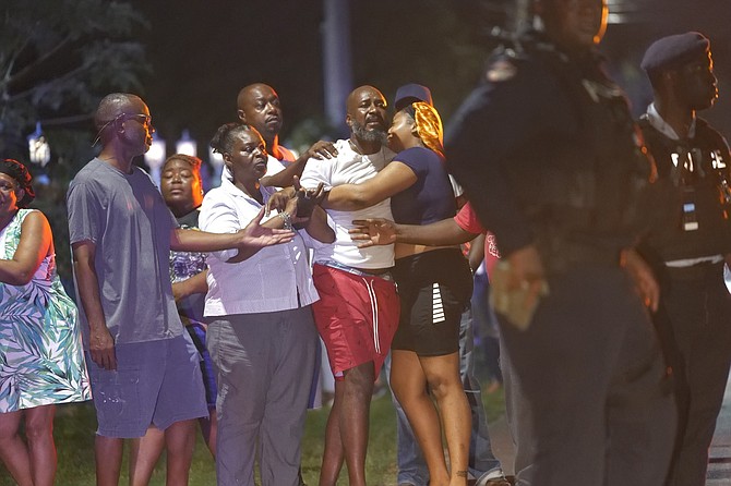 Anguished onlookers at the scene of a fatal shooting last night in the Fox Dale area. See PAGE TWO for story. Photo: Nikia Charlton