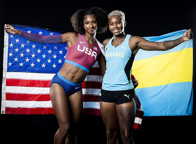 Masai Russell and Devynne Charlton draped with their American and Bahamian flags respectively.