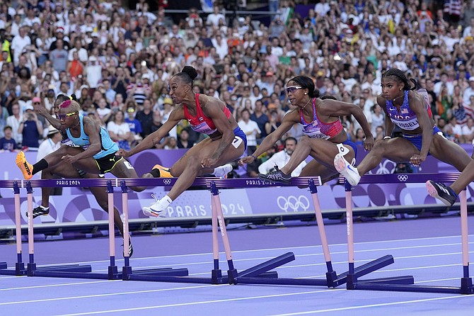 Competitors, including Bahamian Devynne Charlton at far left, race in the women’s 100-metre hurdles final at the 2024 Summer Olympics, Saturday, August 10, 2024, in Saint-Denis, France. 
                                                                                                                                                             (AP Photo/Bernat Armangue)