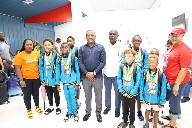 The Grand Bahama Aquatics team received a warm welcome and congratulations from family, friends and local officials upon their return from St. Lucia, including parliamentary secretary in the Ministry for Grand Bahama, Kingsley Smith (centre left) and deputy director of sports in the Ministry of Youth, Sports, and Culture, Norris Bain (centre right), for their outstanding performances. Photos: Jamika Culmer/BIS