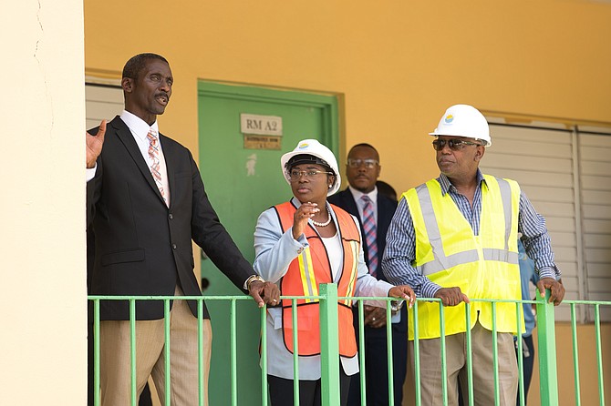 Minister JoBeth Coleby-Davis speaks with officials while touring the solar panel project at C H Reeves High School on August 22, 2024.