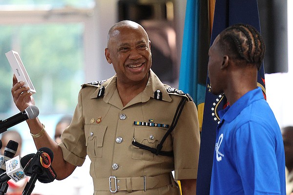 Police Commissioner Clayton Fernander presents a graduate with a new iPhone during the Royal Bahamas Police Force (RBPF) Second Chance Graduation Ceremony at Police Headquarters on Friday. Photo: Dante Carrer/Tribune Staff