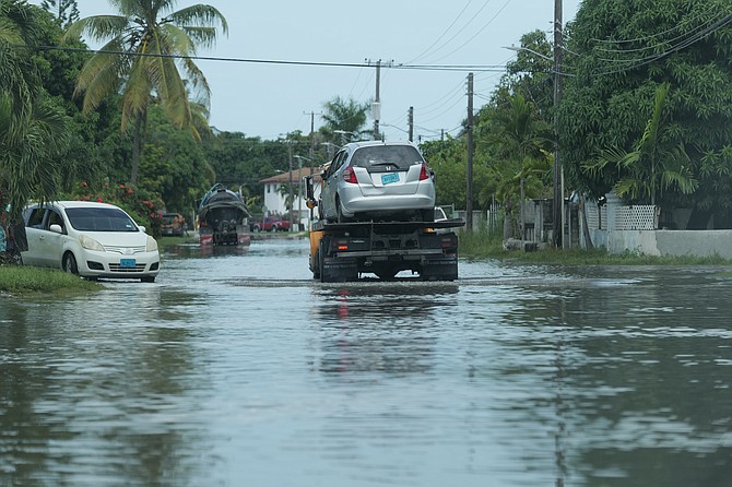 A vehicle being carried by a tow truck down a flooded road in Pinewood Gardens community after heavy rains flooded the area over the weekend.
Photo: Nikia Charlton