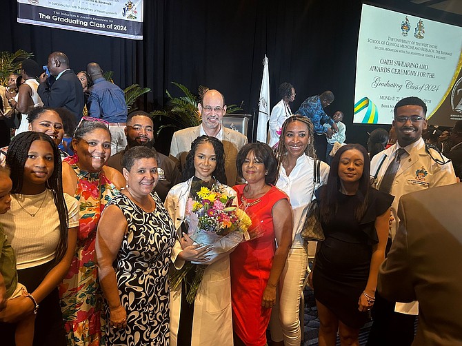 Celeste Adderley, with flowers, surrounded by family and friends as she recently became one of 45 of the newest doctors to graduate from the University of the West Indies School of Clinical Medicine & Research.