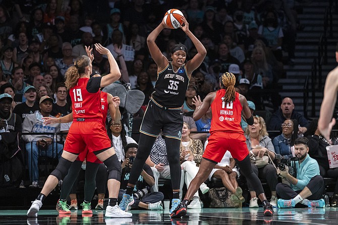 New York Liberty forward Jonquel Jones is defended by Atlanta Dream forward Lorela Cubaj and guard Rhyne Howard during the second half of a WNBA basketball first-round playoff game Sunday, Sept. 22, 2024, in New York. (AP Photo/Corey Sipkin)