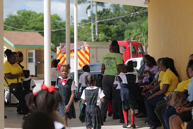 Students and teachers at Uriah McPhee Primary School wait outside as fire disrupted classes yesterday. Photo: Nikia Charlton