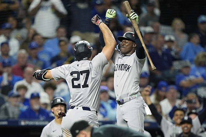 New York Yankees’ Giancarlo Stanton (27) is congratulated by teammate Jasrado “Jazz” Chisholm Jr after hitting a solo home run during the eighth inning in Game 3 of an American League Division baseball playoff series against the Kansas City Royals last night in Kansas City. (AP Photo/Charlie Riedel)