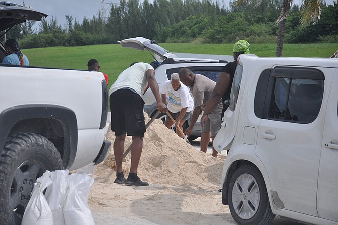 Residents get together to help clear sand and clean roads in West Grand Bahama after the passage of Tropical Storm Milton yesterday. The storm caused power outages and minor flooding in Grand Bahama and Bimini, but left minimal damages overall. Photo: Vandyke Hepburn