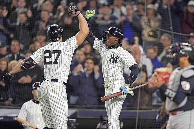 New York Yankees' Giancarlo Stanton (27) celebrates with Jazz Chisholm Jr. after hitting a home run against the Cleveland Guardians during the seventh inning in Game 1 of the baseball AL Championship Series Monday, Oct. 14, 2024, in New York. (AP Photo/Frank Franklin II)