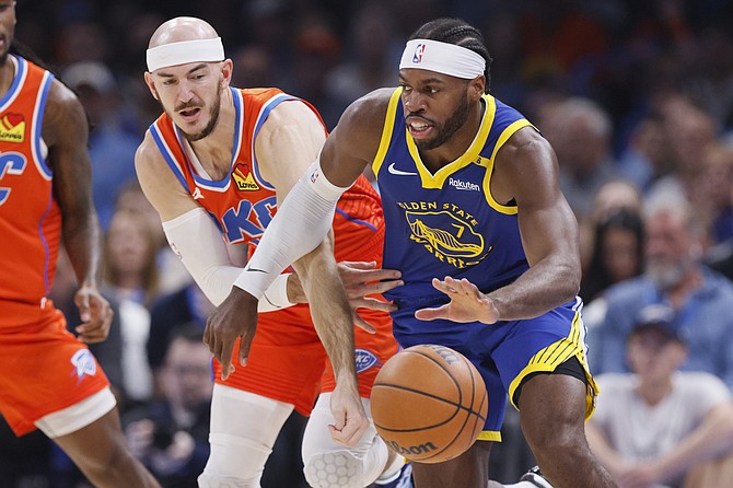 Oklahoma City Thunder guard Alex Caruso, left, tries to steal the ball from Golden State Warriors guard Buddy Hield during the first half of an NBA basketball game, Sunday, Nov. 10, 2024, in Oklahoma City. (AP Photo/Nate Billings)