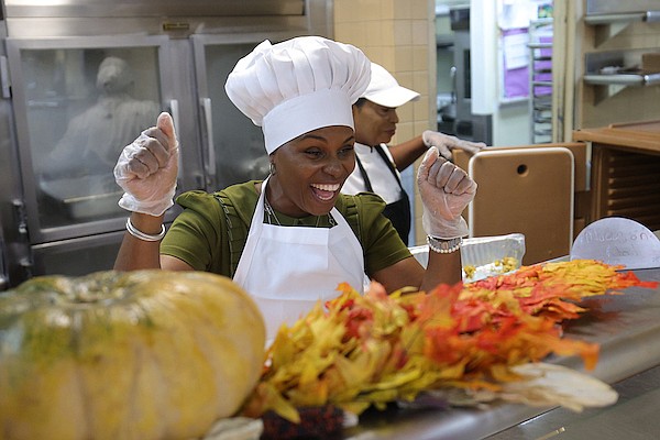 Executives serve Thanksgiving meals to staff members in the Atlantis staff cafeteria on November 28, 2024. Photo: Dante Carrer/Tribune Staff