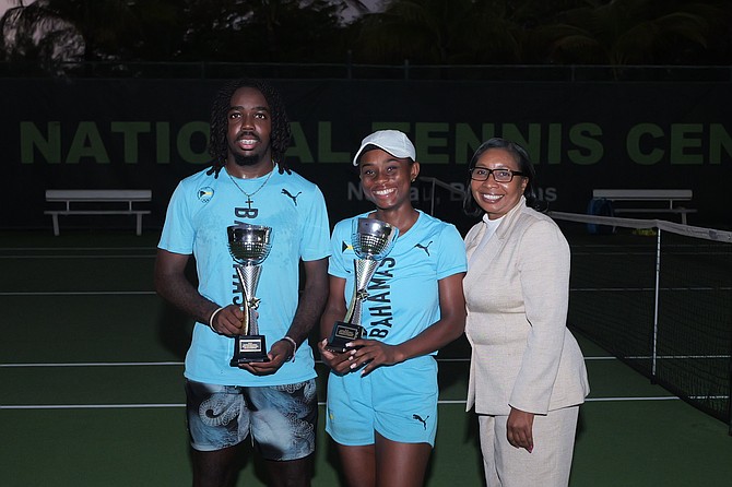 Shown, from left to right, are national tennis champions Denali Nottage and Sydney Clarke with their trophies and Chilean Burrows, vice president of the Bahamas Lawn Tennis Association. Photo: Chappell Whyms Jr