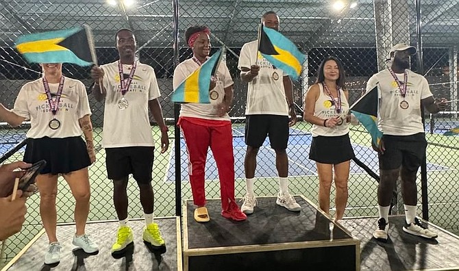 TEAM Bahamas, waving their national flags, celebrate on the medal dais with a gold, silver and bronze at the Pickleball Nations Cup in the Cayman Islands over the weekend.
