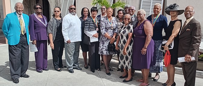 Erin Adderley (white shirt) poses with members of the women’s national softball team, led by manager Bobby Baylor Fernander (left) and coach Ali C.
